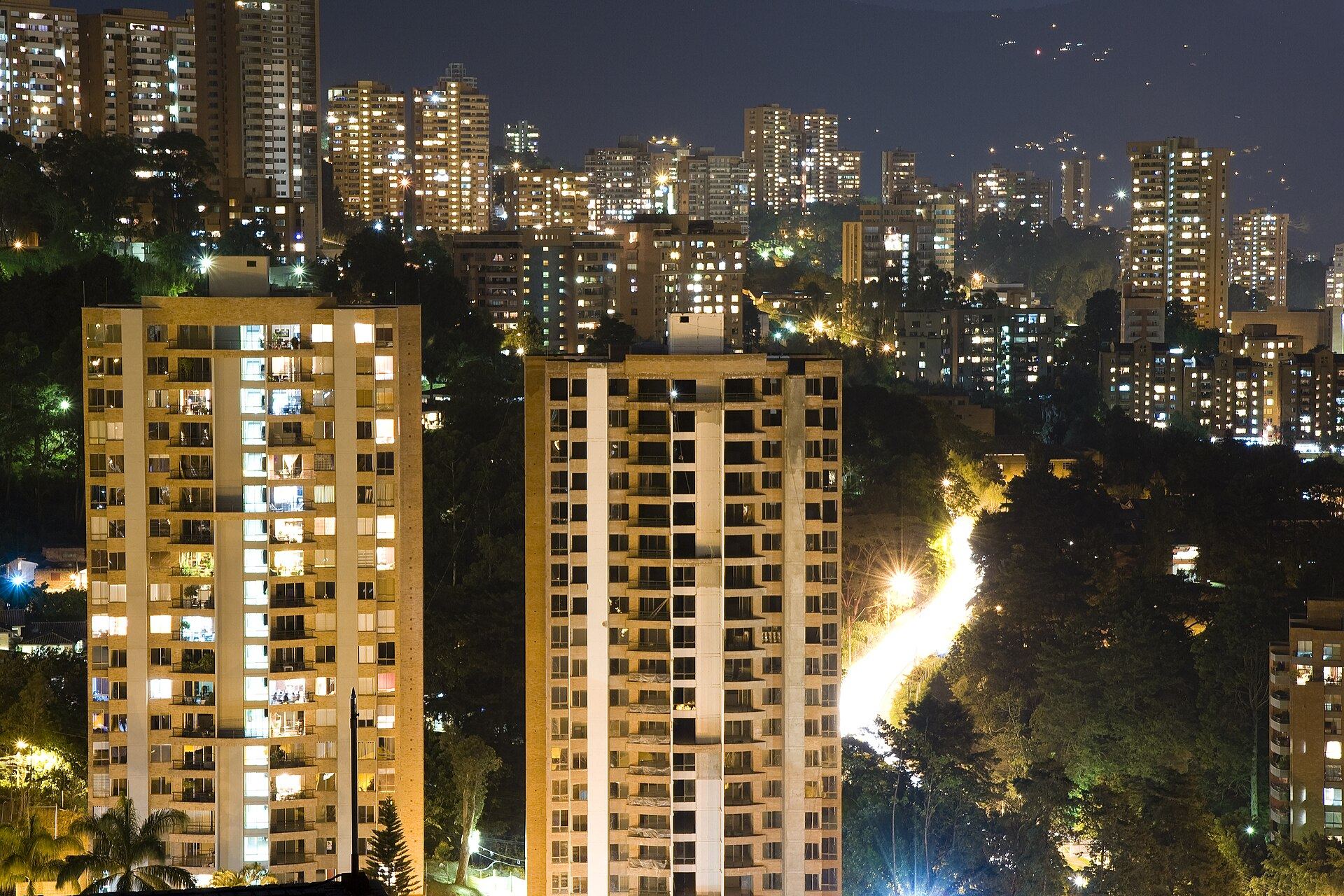 El Poblado at night: lit towers in the green hills of Medellín