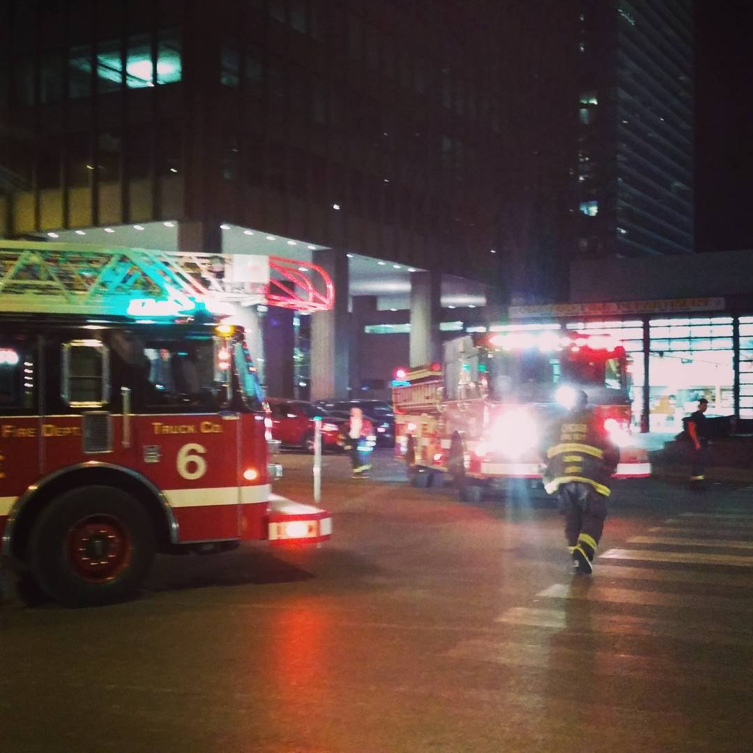 Chicago Fire Department Truck 6 and an engine at night downtown, a firefighter crossing the street
